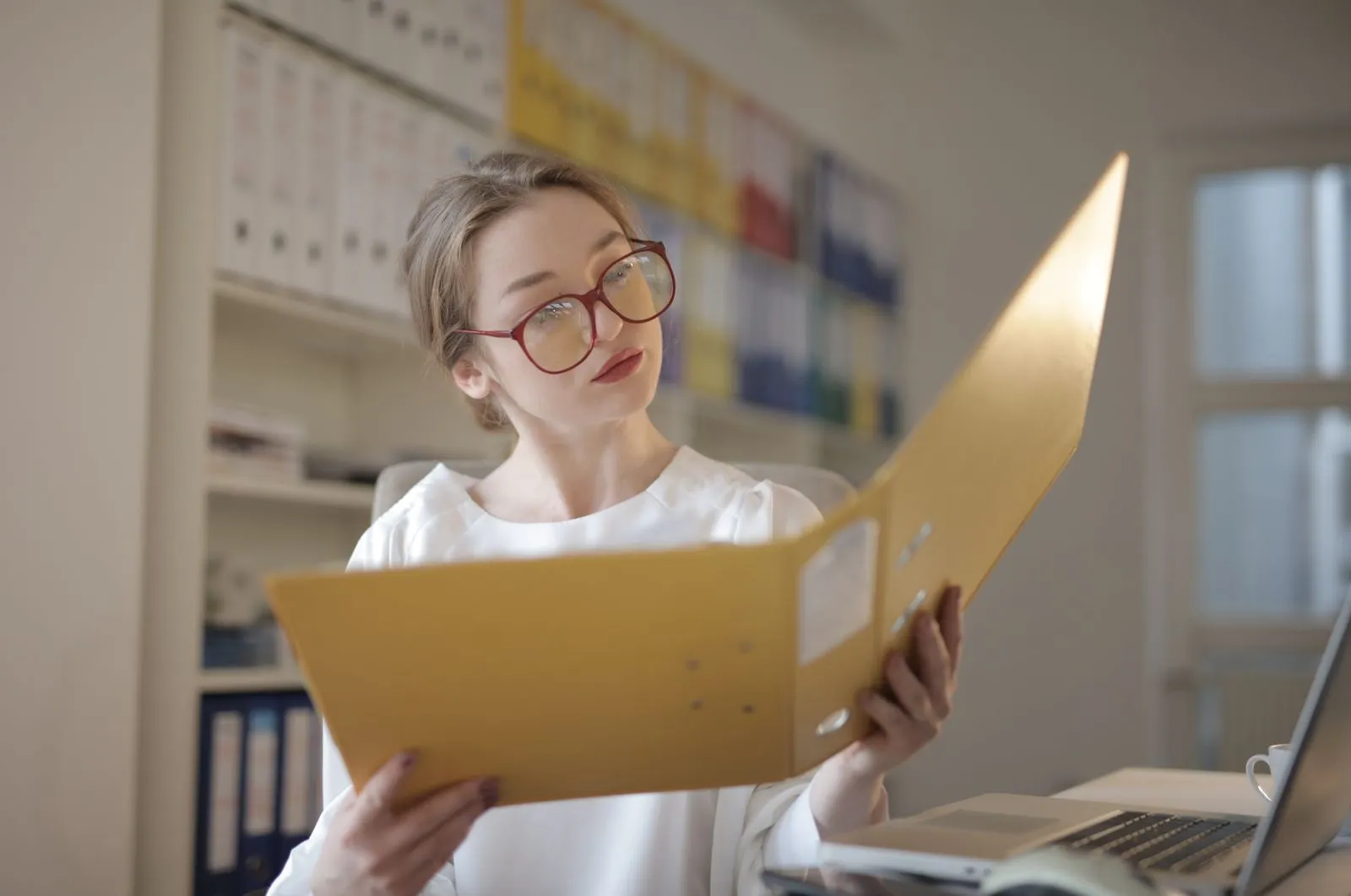 A researcher consulting a folder in a records office.