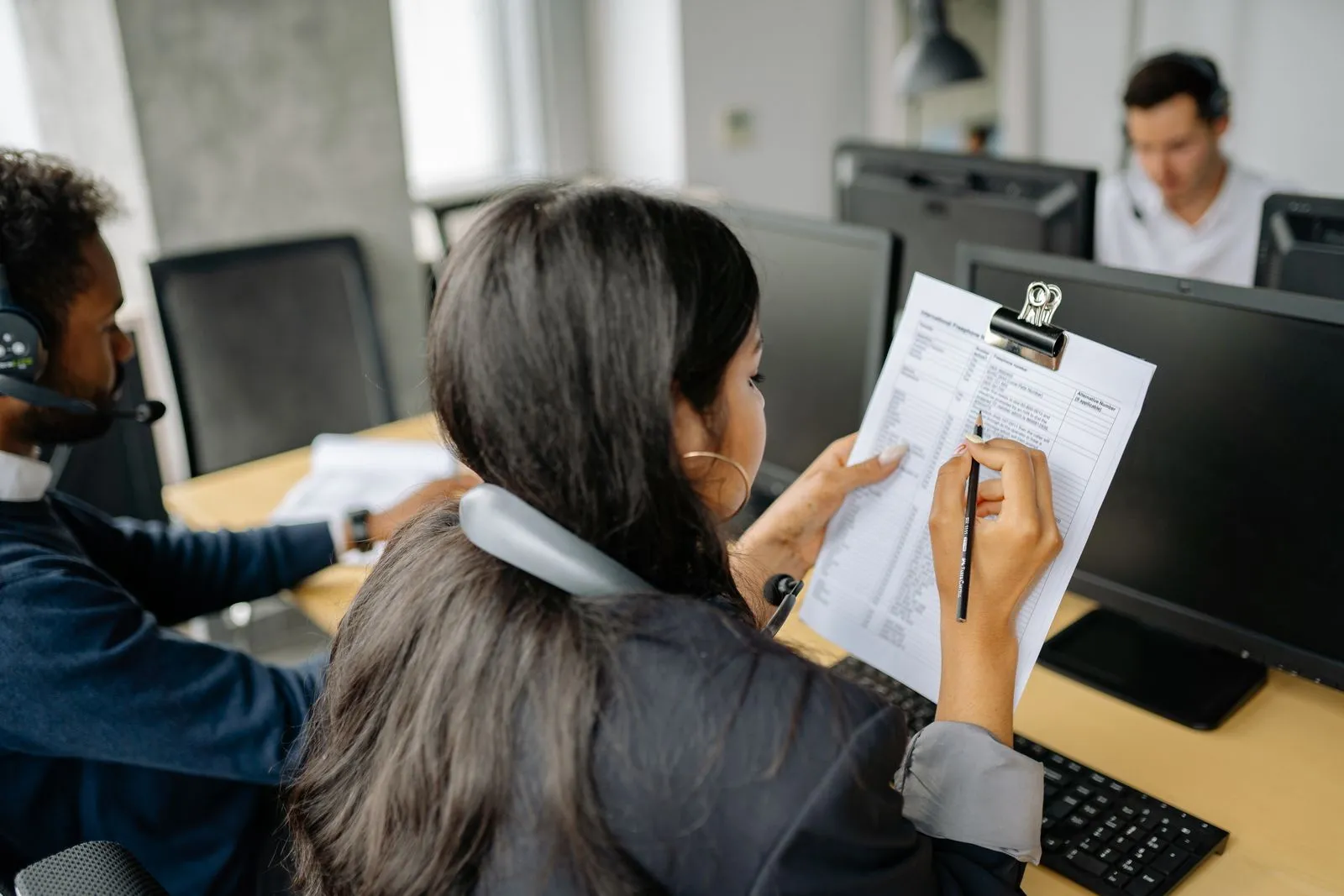 An operator reviewing a checklist at a computer workstation.