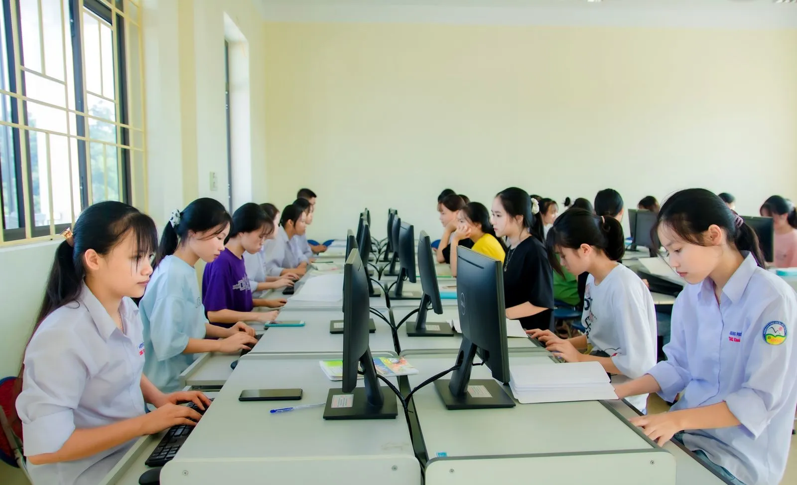 Students working at computers in a classroom.