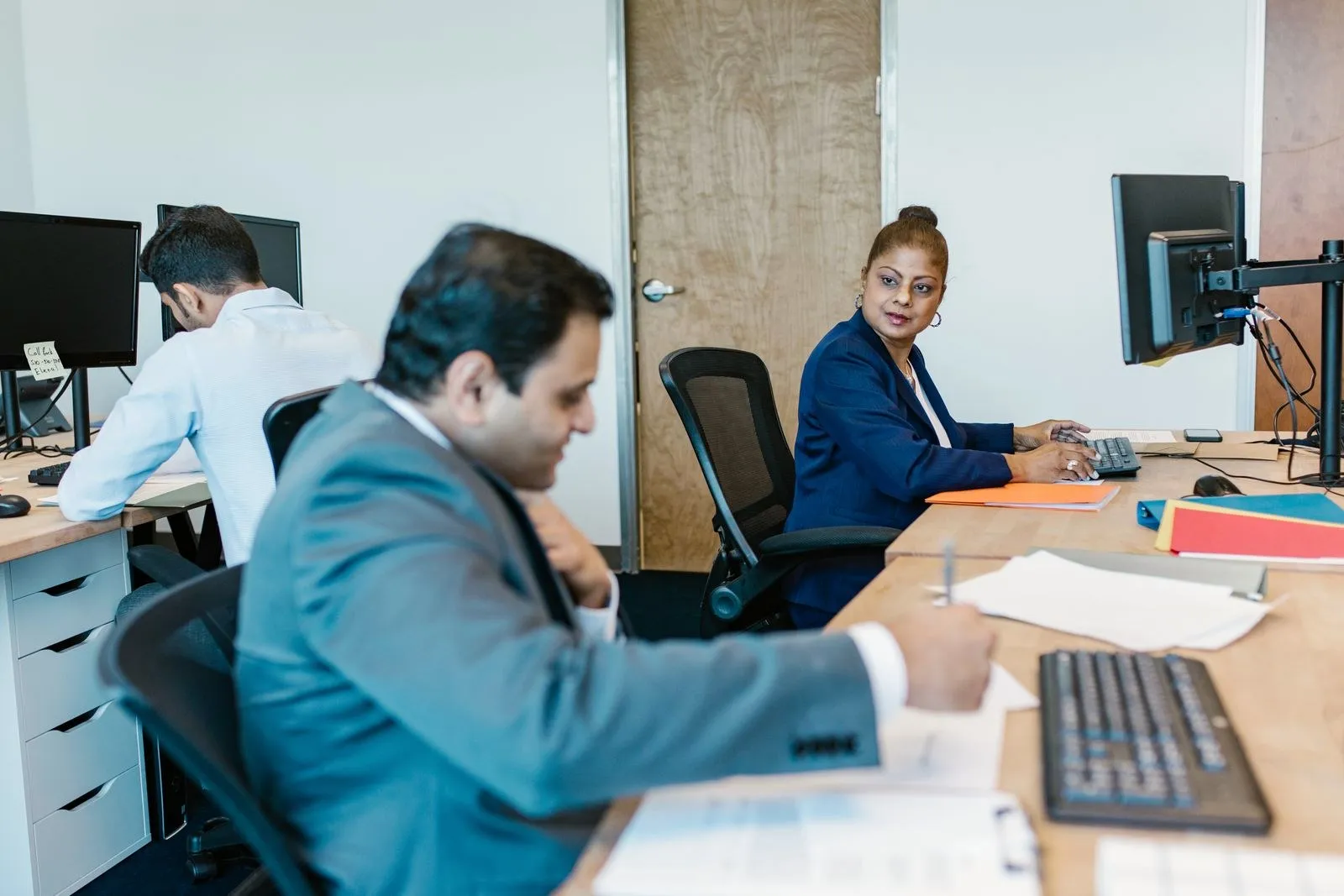 Professionals working at computers in an office.