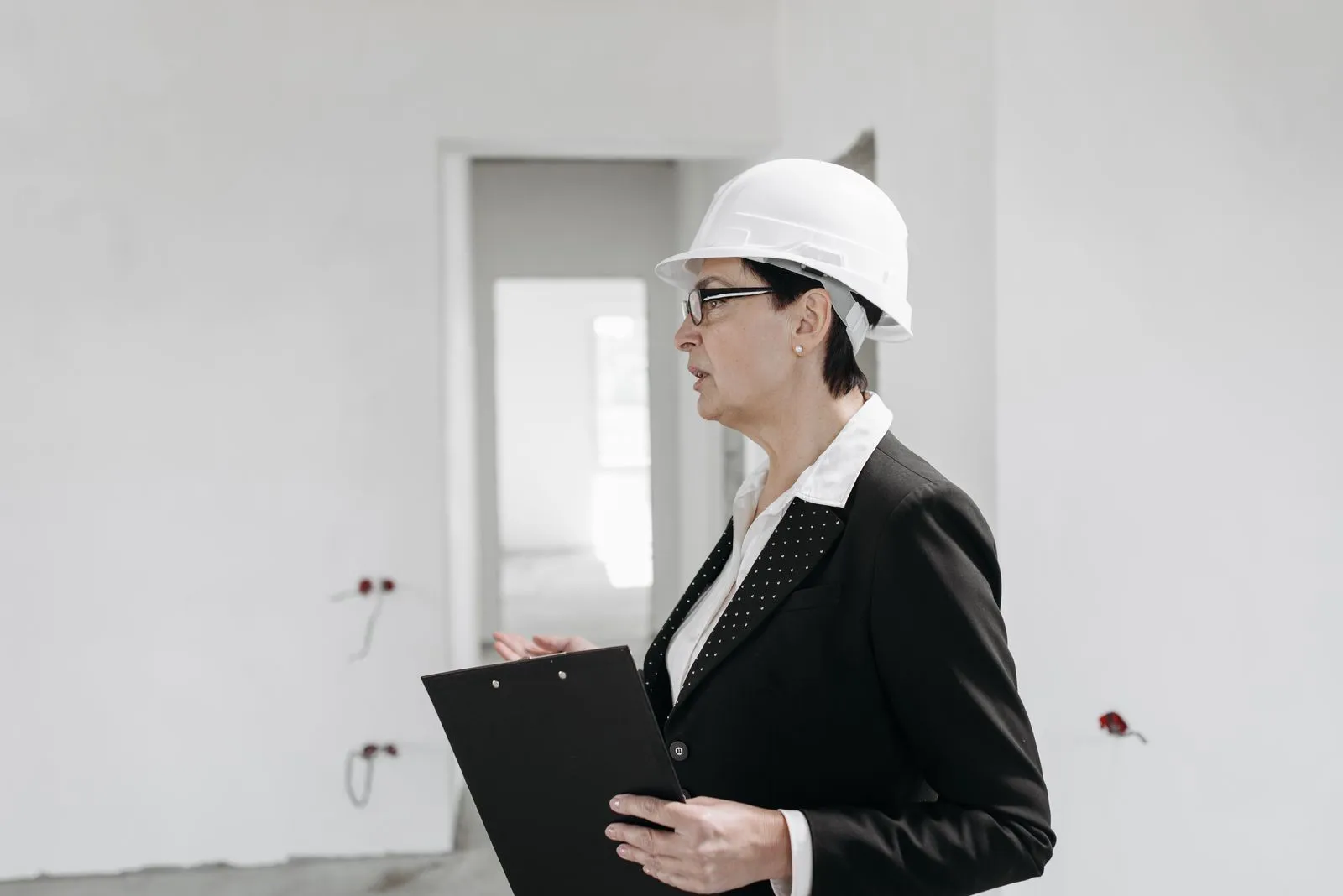 An engineer in a hard hat holding a clipboard.